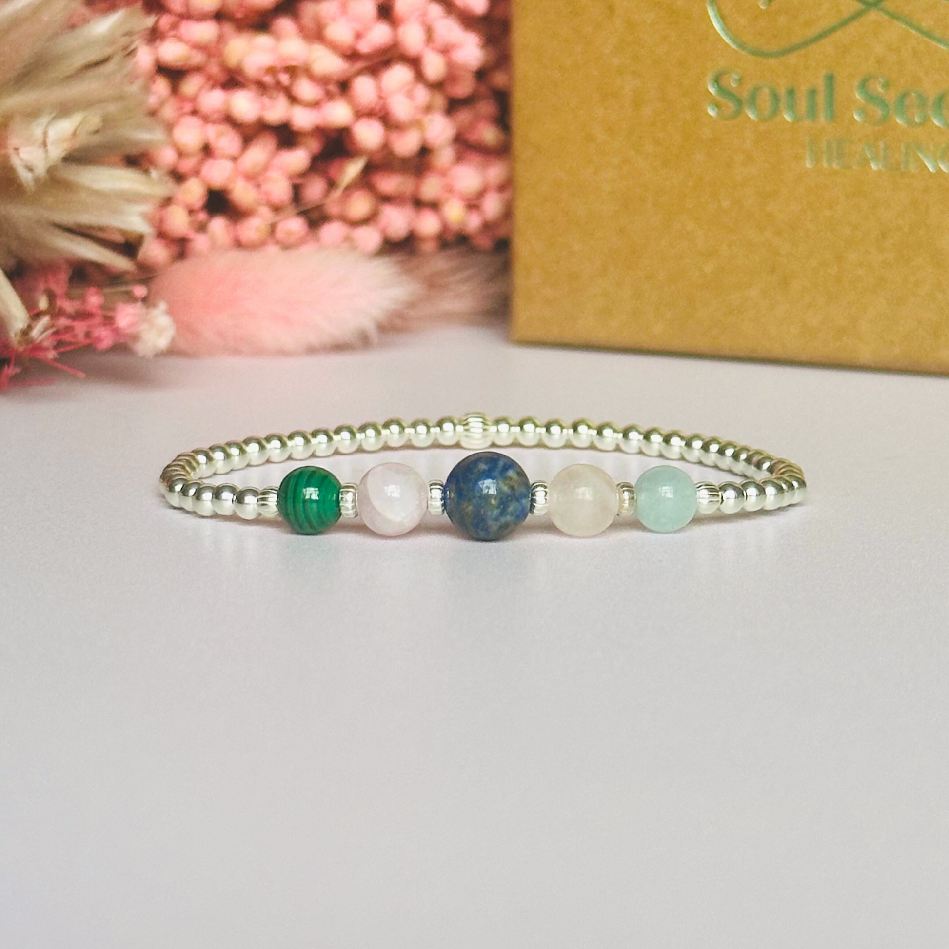 This sterling silver Taurus bracelet is made with a selection of five healing crystals all believed to resonate with the Taurus zodiac sign. The central bead is 8mm, the other four are 6mm. On an elasticated band of 3mm sterling silver beads with corrugated accent beads. Featuring malachite, lapis lazuli, rose quartz, kunzite and aquamarine.