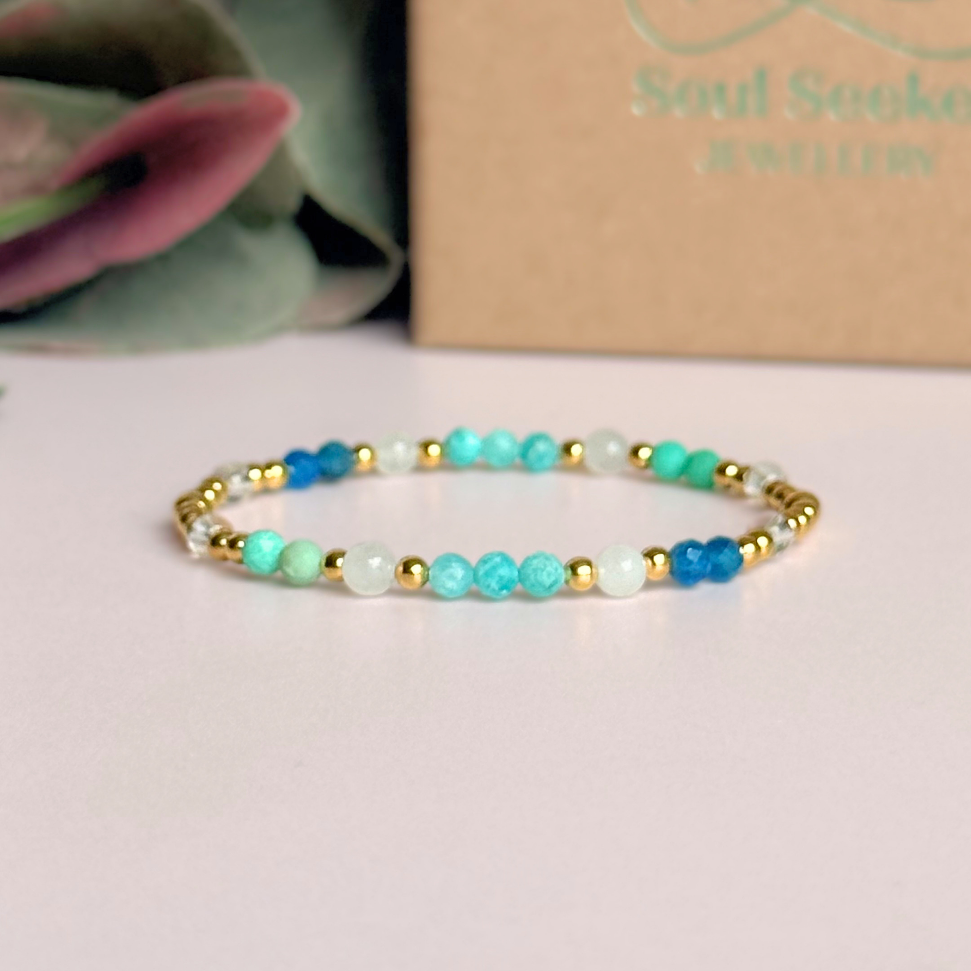 ‘Caribbean Dream' gold vermeil dainty beaded bracelet with white jade, chrysoprase, amazonite, apatite and clear quartz. Made with round 3mm gold vermeil beads and 4mm smooth and faceted round crystal gemstone beads. Pictured in front of the gift box 