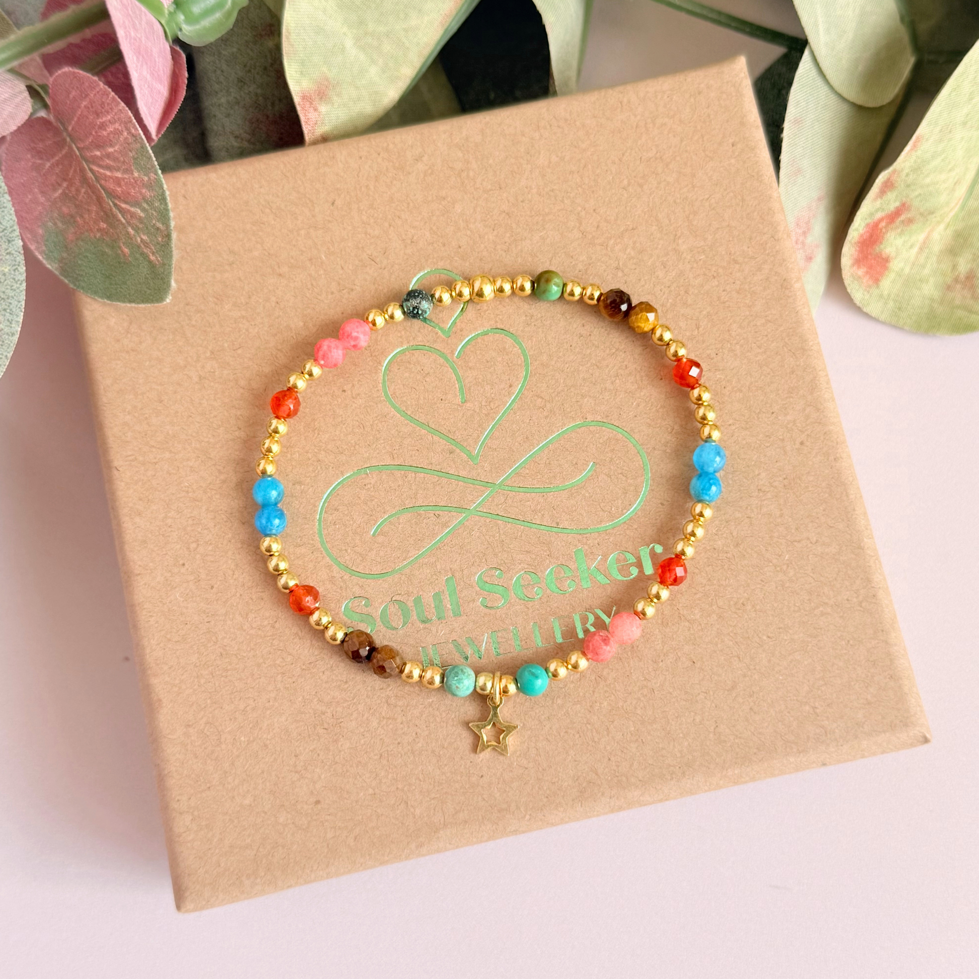 'Hot girl summer' gold vermeil dainty beaded bracelet with tigers eye, turquoise, apatite, carnelian and rhodochrosite. With a beautiful open star charm.Made with round 3mm gold vermeil beads and 4mm smooth and faceted round crystal gemstone beads. Pictured from above, on top of the gift box.