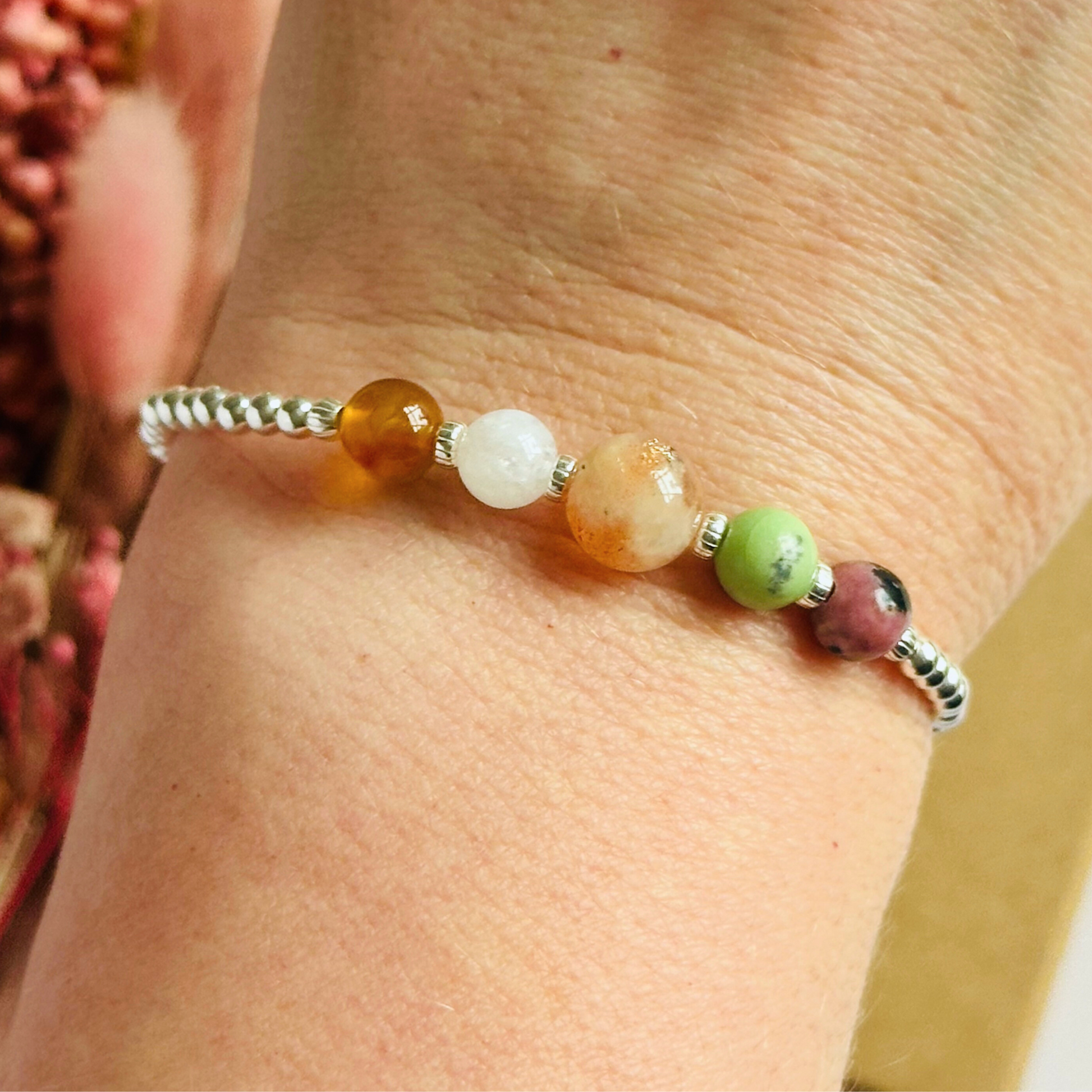 This sterling silver Cancer bracelet is made with a selection of five healing crystals all believed to resonate with the Cancer zodiac sign. The central bead is 8mm, the other four are 6mm. On an elasticated band of 3mm sterling silver beads with corrugated accent beads. Featuring chrysoprase, rhodonite, sunstone, carnelian and moonstone.