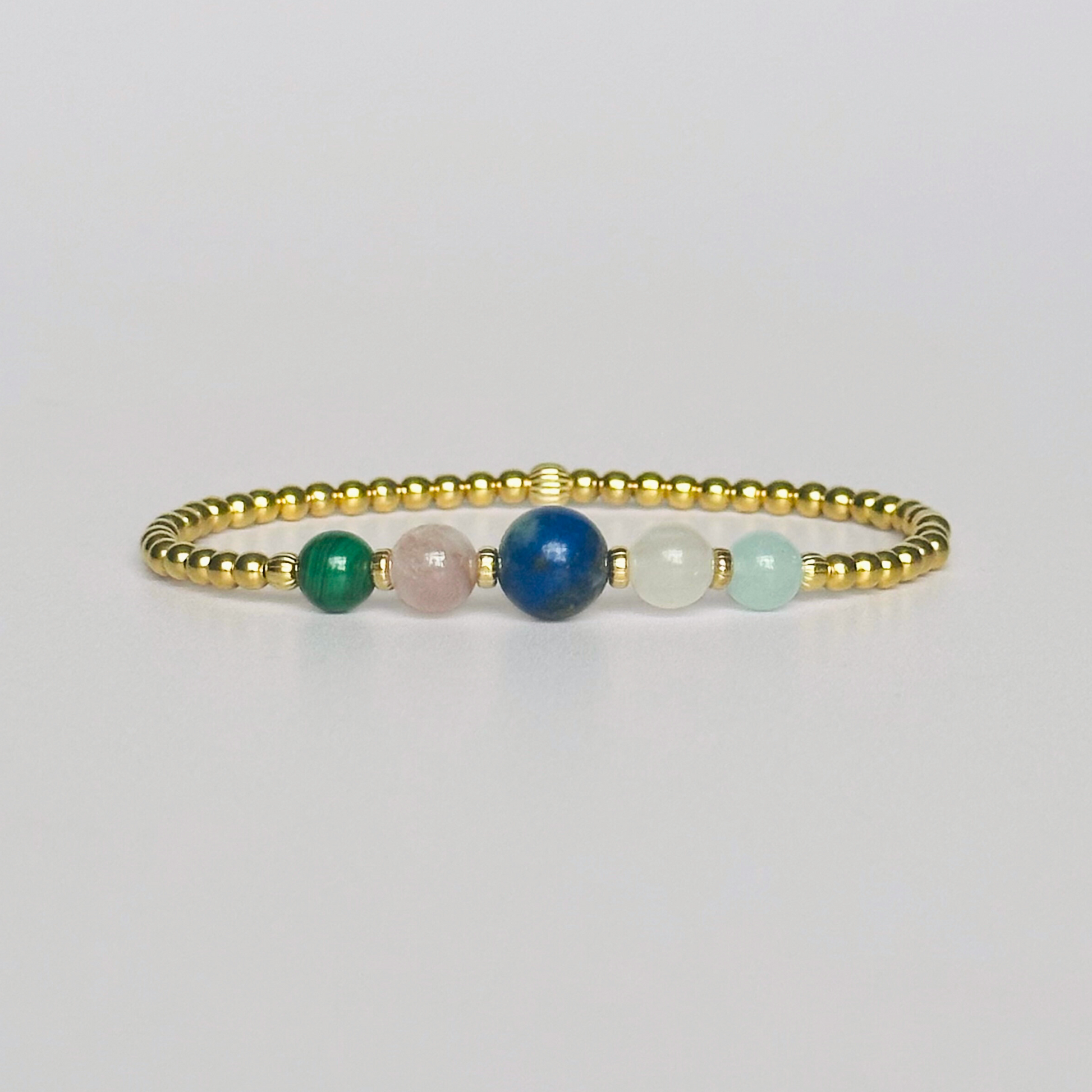 This gold vermeil Taurus bracelet is made with a selection of five healing crystals all believed to resonate with the Taurus zodiac sign. The central bead is 8mm, the other four are 6mm. On an elasticated band of 3mm gold vermeil beads with corrugated accent beads. Featuring malachite, lapis lazuli, rose quartz, kunzite and aquamarine.
