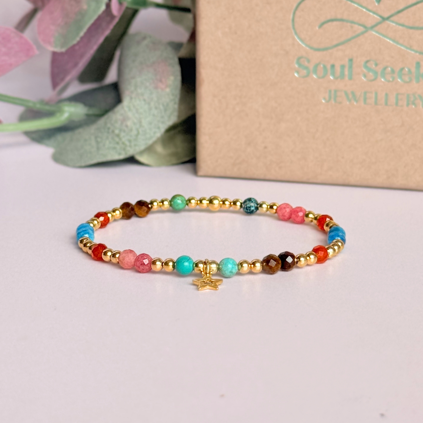 'Hot girl summer' gold vermeil dainty beaded bracelet with tigers eye, turquoise, apatite, carnelian and rhodochrosite. With a beautiful open star charm.Made with round 3mm gold vermeil beads and 4mm smooth and faceted round crystal gemstone beads. Pictured in front of the gift box.