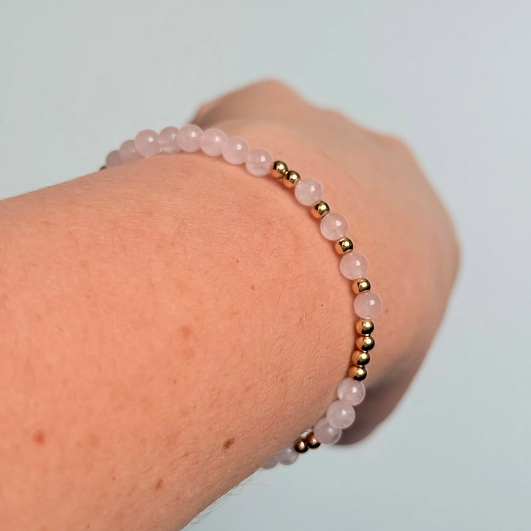 Morse code secret message bracelet spelling out the words Mum est. 2025 in gold filled and rose quartz crystal beads. elasticated with 4mm rose quartz beads and 3mm gold filled beads.