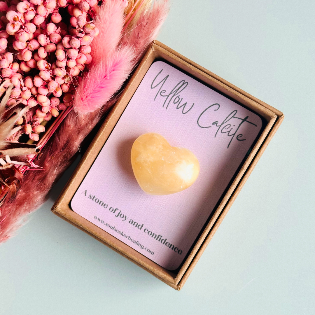 A beautiful ethically mined yellow calcite heart, presented on an eco-friendly textured card with the words 'A stone of joy and confidence.' This heart shaped crystal measures approximately 25mm x 25mm.