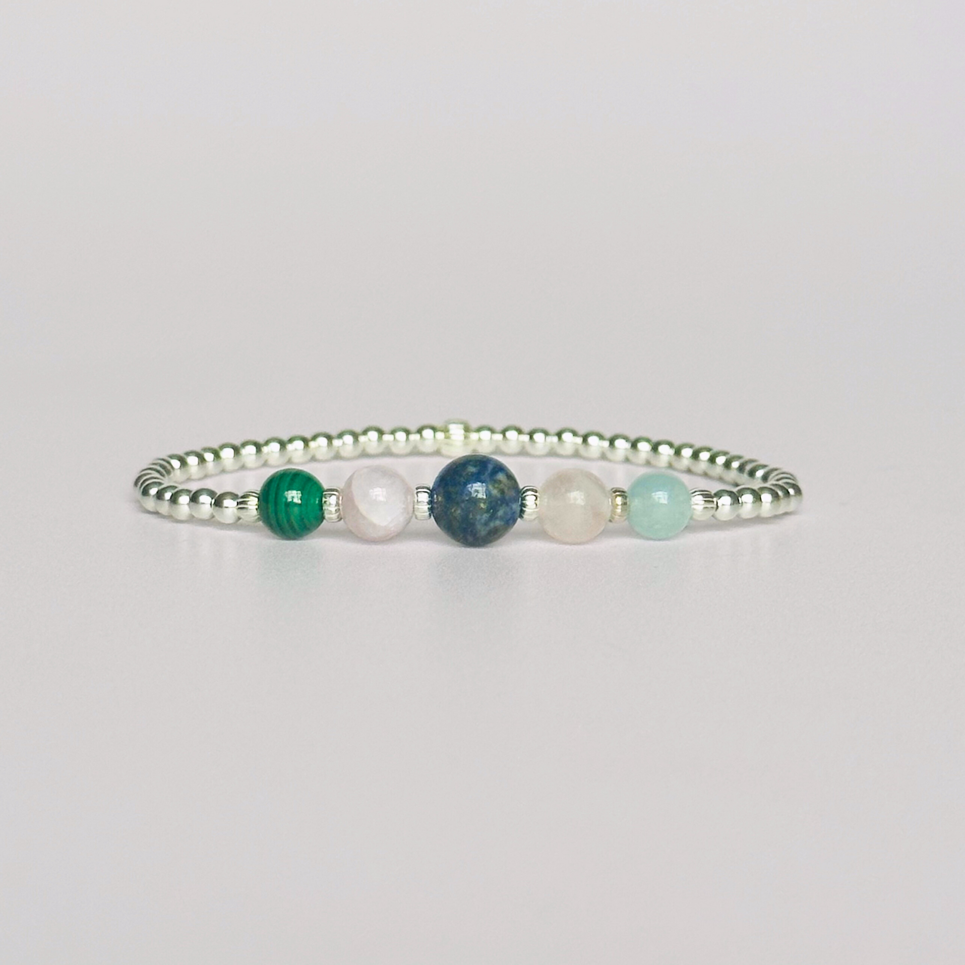 This sterling silver Taurus bracelet is made with a selection of five healing crystals all believed to resonate with the Taurus zodiac sign. The central bead is 8mm, the other four are 6mm. On an elasticated band of 3mm sterling silver beads with corrugated accent beads. Featuring malachite, lapis lazuli, rose quartz, kunzite and aquamarine.