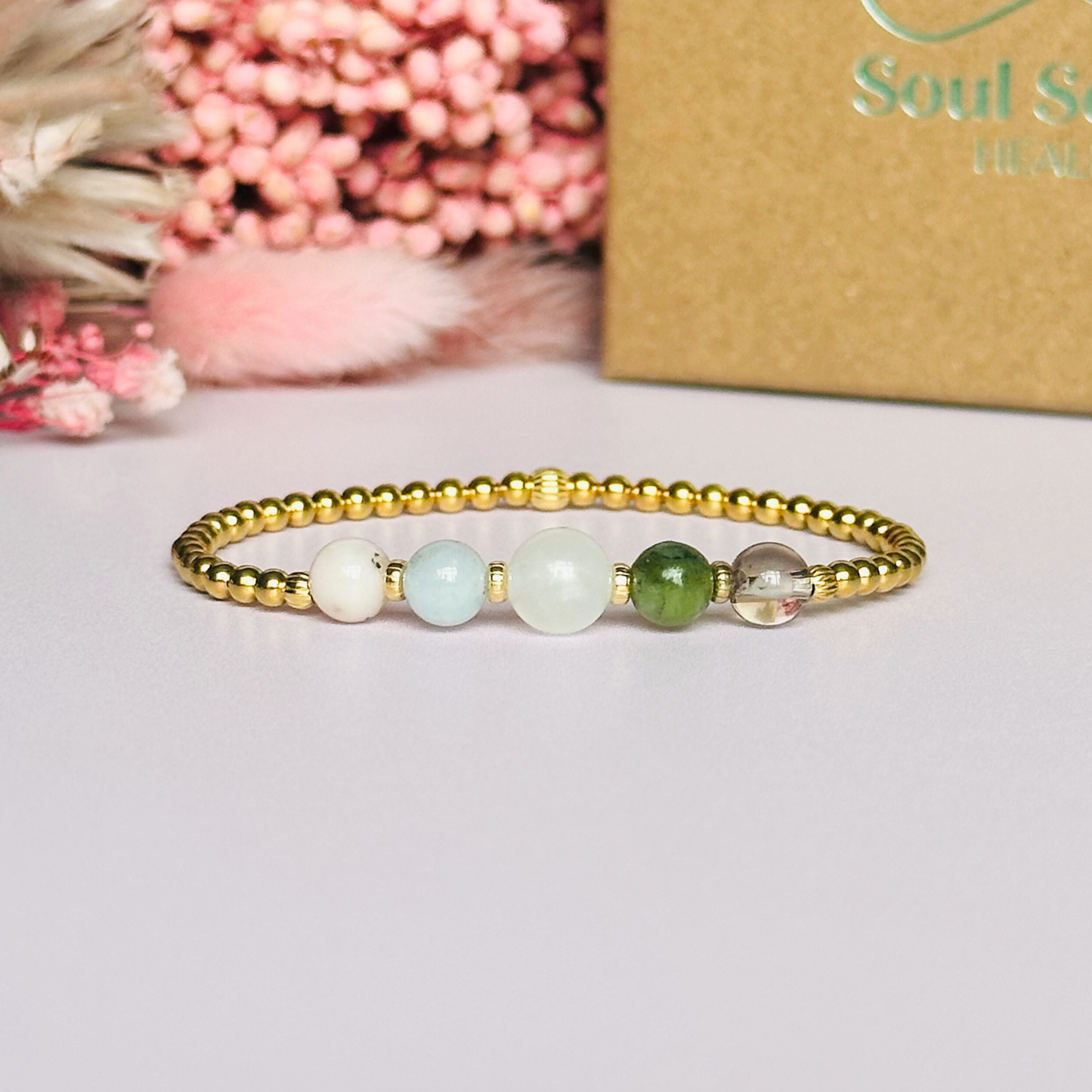 This gold vermeil Libra bracelet is made with a selection of five healing crystals all believed to resonate with the Libra zodiac sign. The central bead is 8mm, the other four are 6mm. On an elasticated band of 3mm gold vermeil beads with corrugated accent beads. Featuring ametrine, jade, moonstone, aquamarine and pink opal.
