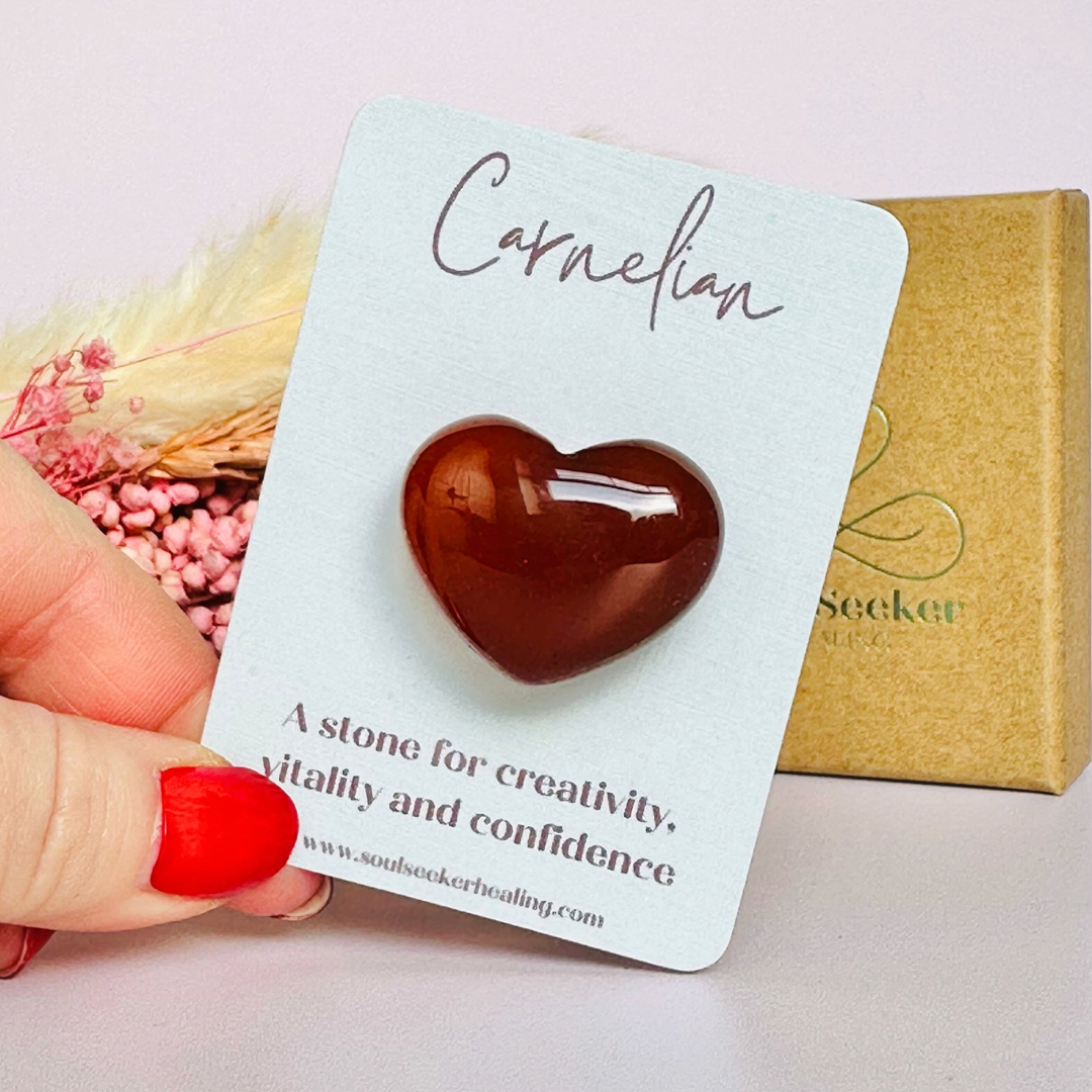 A beautiful ethically mined carnelian heart, presented on an eco-friendly textured card with the words 'A stone for creativity, vitality and confidence.' This heart shaped carnelian crystal measures approximately 25mm x 25mm.