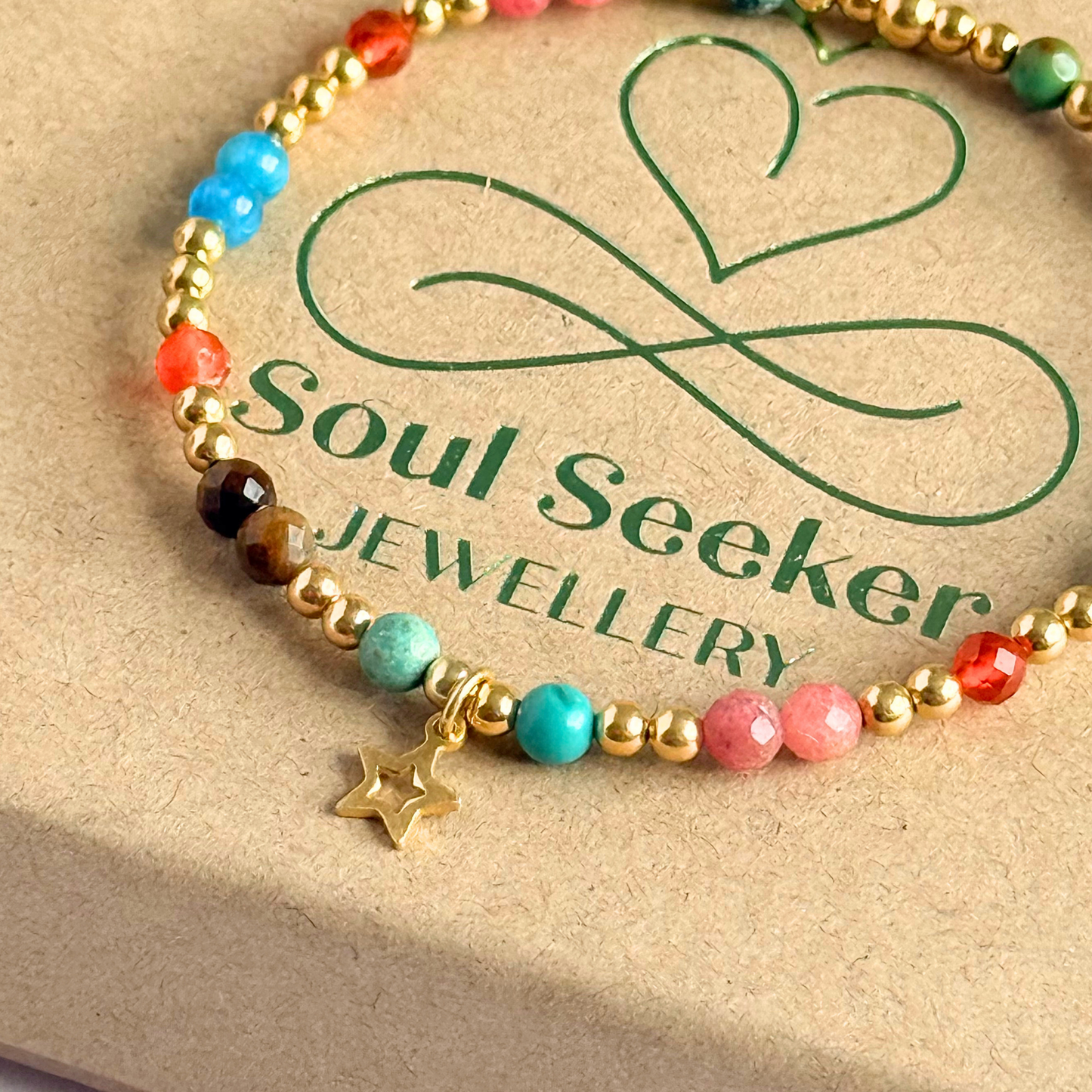 'Hot girl summer' gold vermeil dainty beaded bracelet with tigers eye, turquoise, apatite, carnelian and rhodochrosite. With a beautiful open star charm.Made with round 3mm gold vermeil beads and 4mm smooth and faceted round crystal gemstone beads. Pictured close up, on top of the gift box.