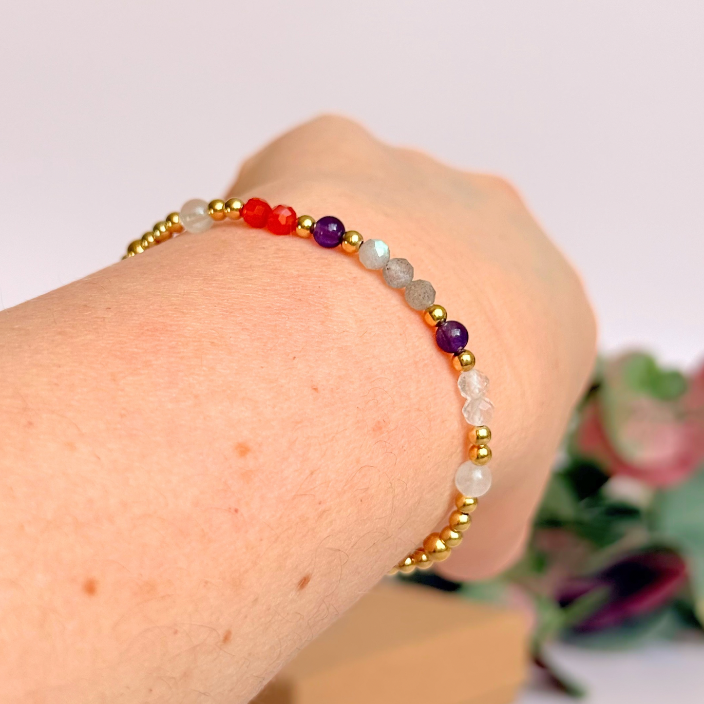 Dainty gold vermeil crystal bracelet featuring five crystals, in 4mm faceted and smooth round style, each believed to help with hormonal balance. Featuring amethyst, moonstone, carnelian, labradorite and rose quartz. Pictured being worn, on an angle.