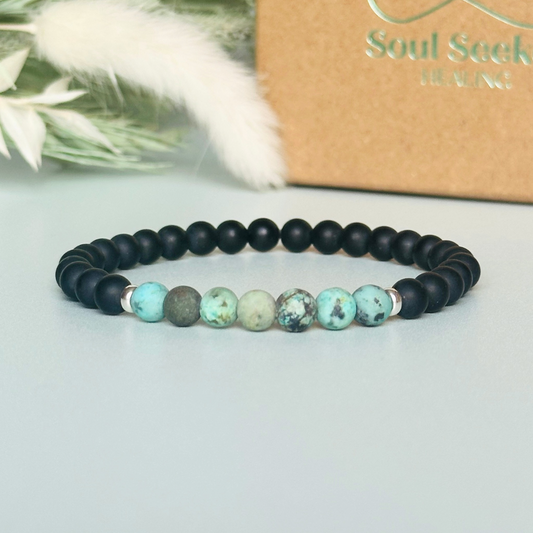 Men’s crystal bracelet featuring 6mm matte black onyx beads, 6mm matte African turquoise beads with sterling silver spacer beads.