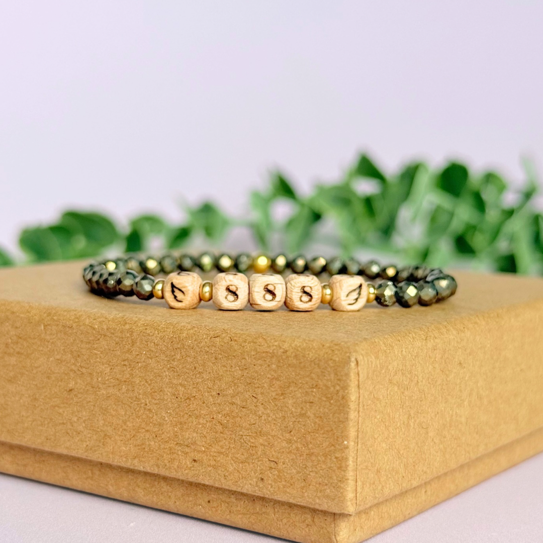 Bracelet featuring engraved wooden 888 angel number and wing beads, on the band of 4mm faceted pyrite round crystal gemstone beads. Finished with your choice of gold vermeil, sterling silver or rose gold vermeil accent beads.