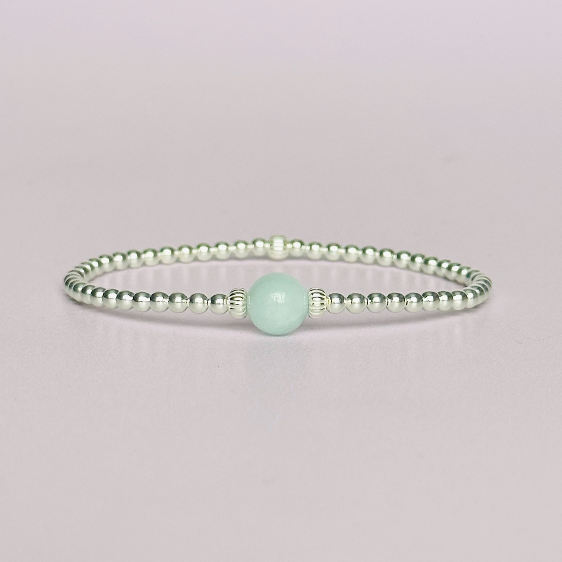 Sterling silver aquamarine bracelet features an ethically mined 8mm aquamarine bead, flanked by corrugated rondelle beads on a band of 3mm sterling silver beads. A bracelet to promote courage and self expression.