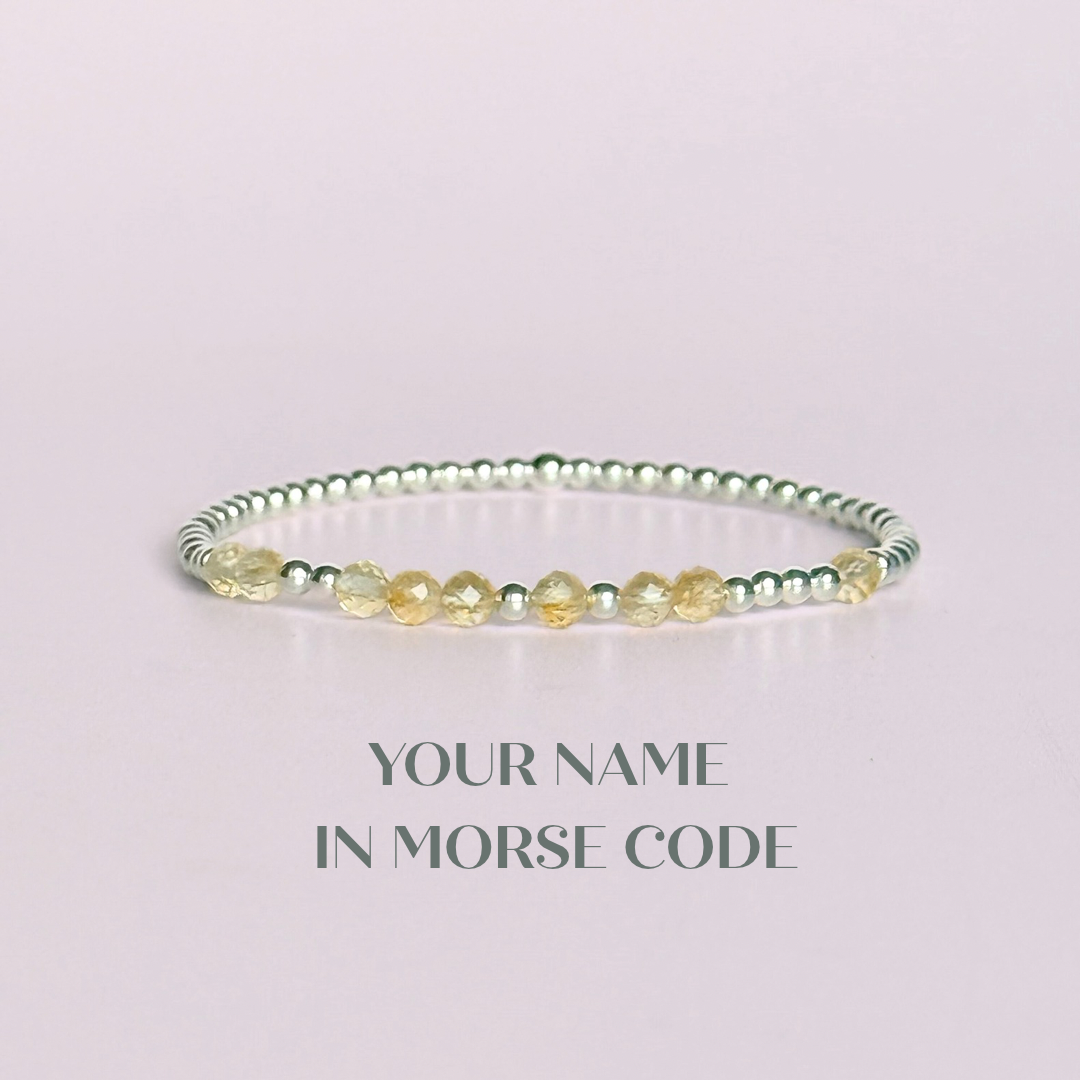 Morse code secret message bracelet spelling out your chosen name in sterling silver and citrine crystal beads. Elasticated with 4mm faceted citrine beads and 3mm sterling silver beads. Custom November birthstone bracelet.