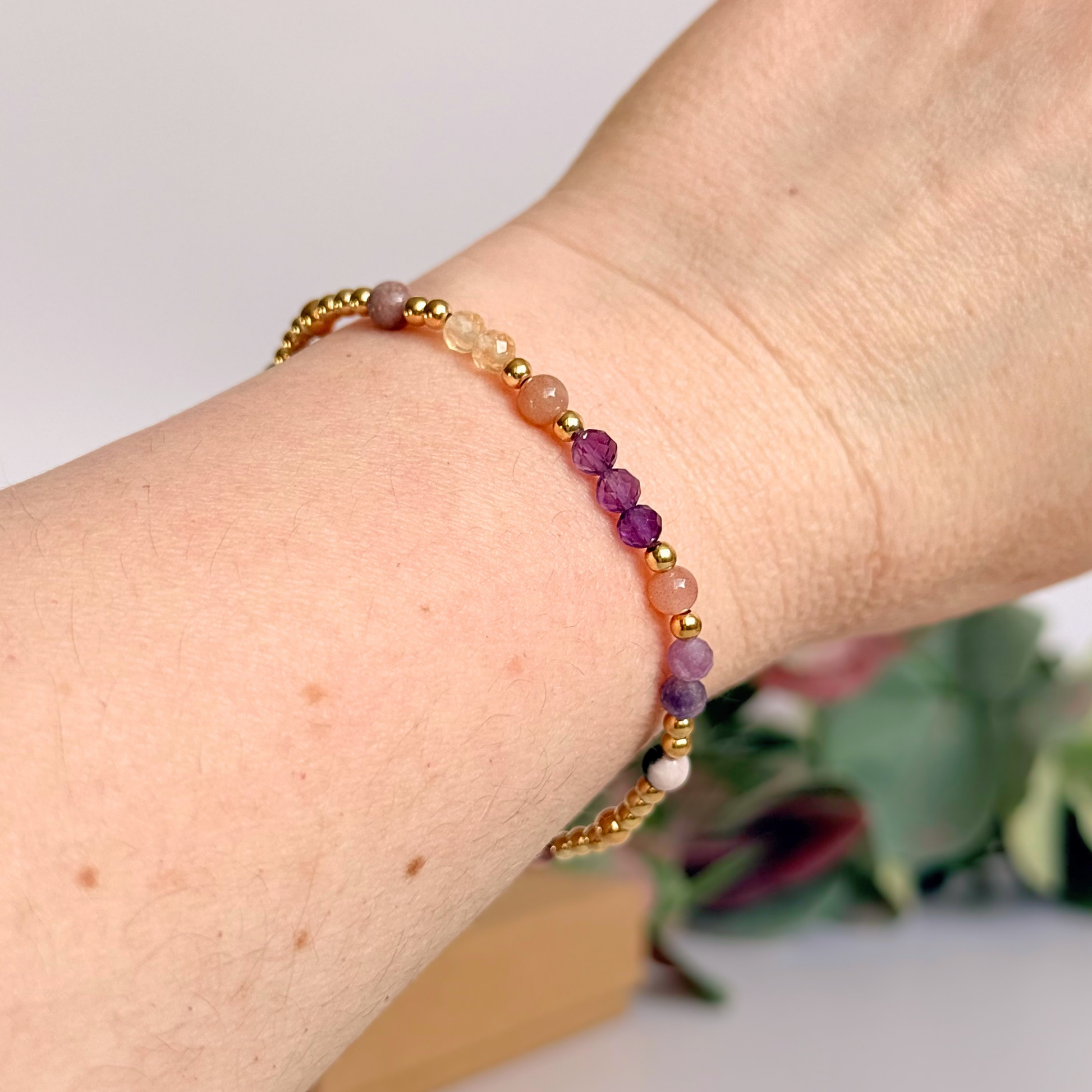 Dainty gold vermeil crystal bracelet featuring five crystals, in 4mm faceted and smooth round style, each believed to help with menopause symptoms. Featuring amethyst, citrine, lepidolite, peach moonstone and pink zebra jasper. Pictured being worn.