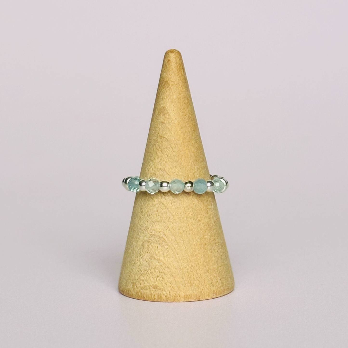Sterling silver aquamarine ring featuring five 3mm faceted round aquamarine beads on a elasticated ring band of 2.5mm gold vermeil beads. March birthstone ring.