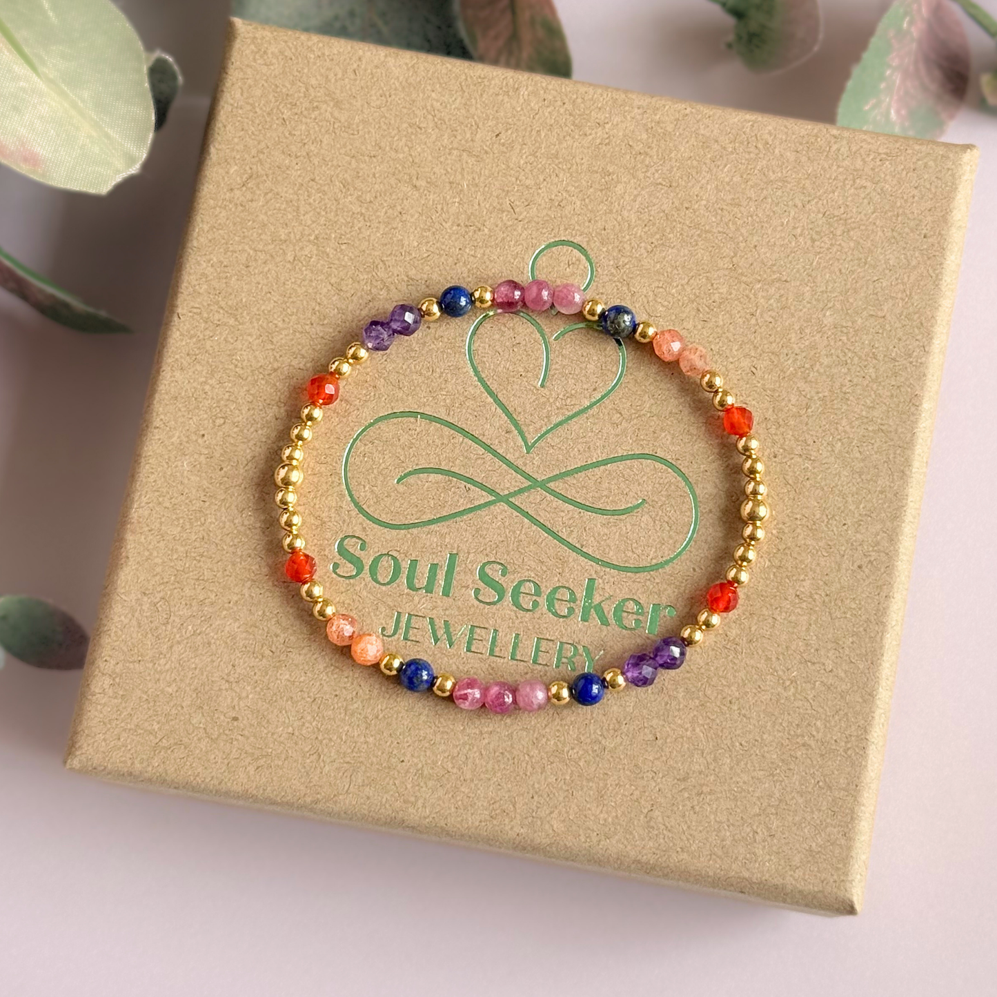 ‘Arabian Sunset' gold vermeil dainty beaded bracelet with pink tourmaline, sunstone, carnelian, lapis lazuli and amethyst. Made with round 3mm gold vermeil beads and 4mm smooth and faceted round crystal gemstone beads. Pictured on top of the box