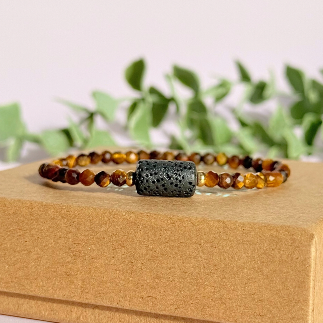 Essential oil diffuser bracelet featuring black lava rock tube bead on the band of 4mm faceted tigers eye beads. Finished with your choice of sterling silver or gold vermeil accent beads.