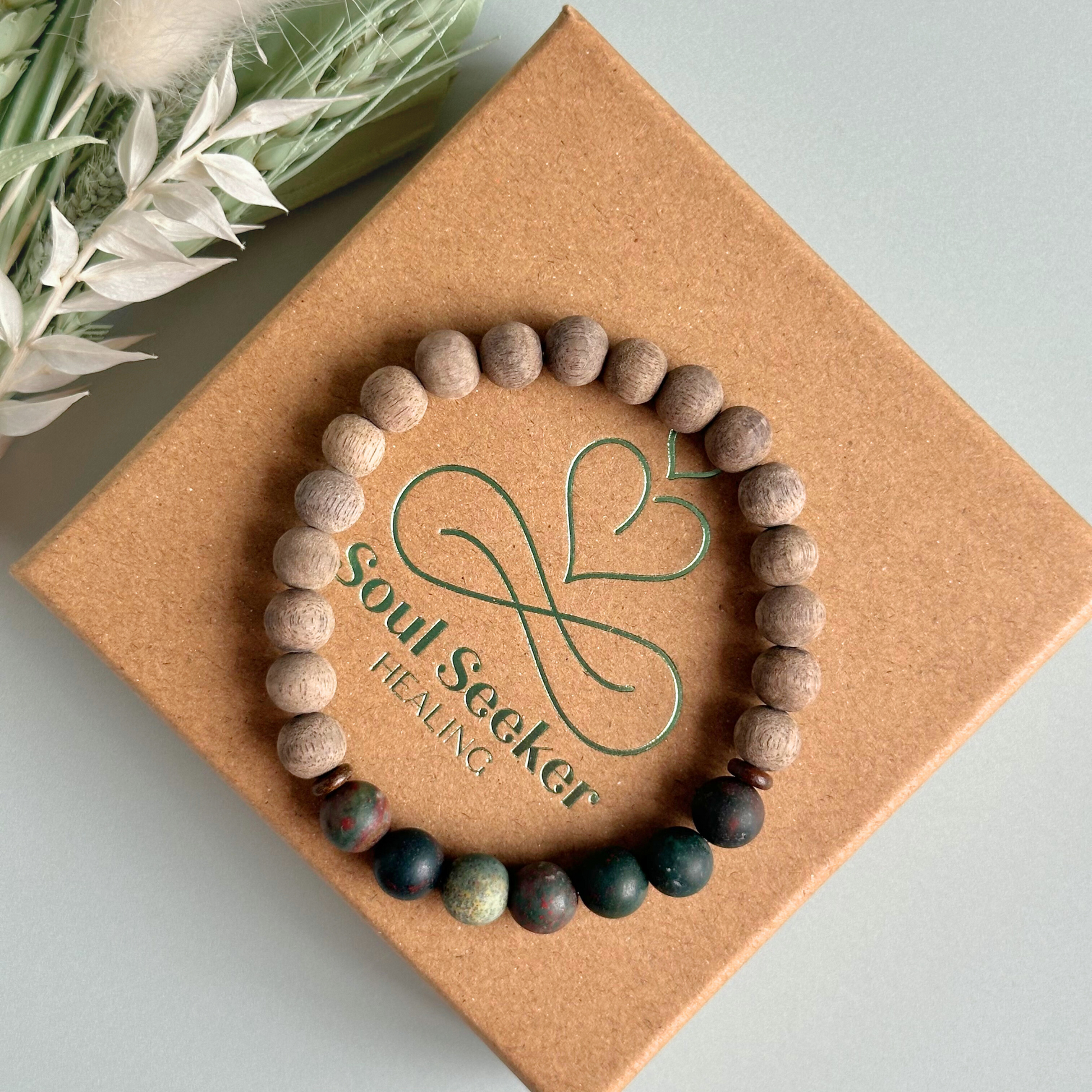 Men’s crystal bracelet featuring 8mm matte bloodstone beads, 8mm raw greywood beads with sandalwood spacer beads.