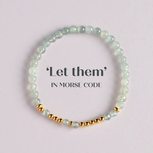 Elasticated labradorite crystal morse code bracelet that spells out the words ‘Let them’ in a combination of 4mm round labradorite beads, 4mm faceted labradorite beads and either sterling silver or gold vermeil 3mm round beads. The words start and end at the rondelle spacer beads.

