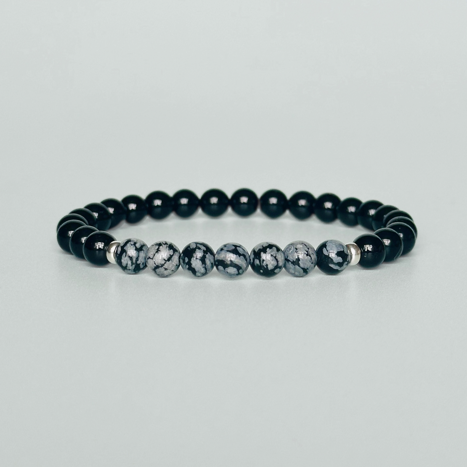 Men’s crystal bracelet featuring 6mm black tourmaline beads, 6mm snowflake obsidian beads with sterling silver spacer beads.