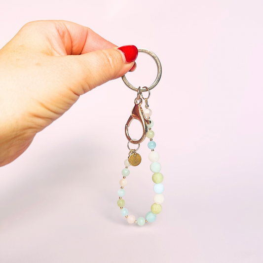Frosted morganite breath work beads on a rose gold keychain/bag charm. For the 4-7-8 counted breathing method.