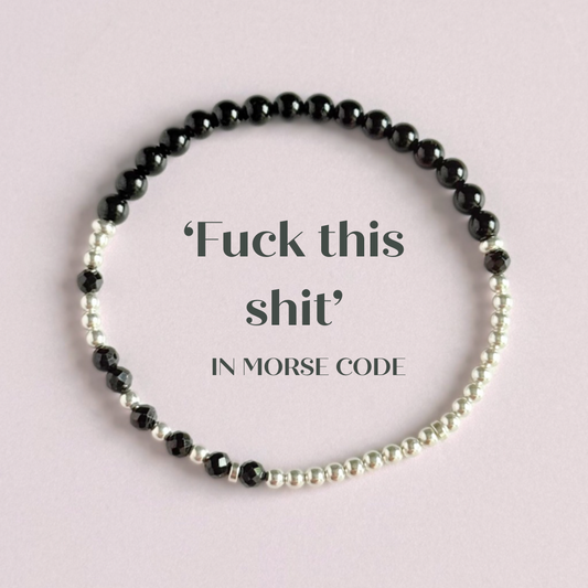 Elasticated black tourmaline crystal morse code bracelet spells out the words ‘Fuck this shit’ in a combination of 4mm round black tourmaline beads, 4mm faceted black tourmaline beads and either sterling silver or gold vermeil 3mm round beads. The words start and end at the rondelle spacer beads.