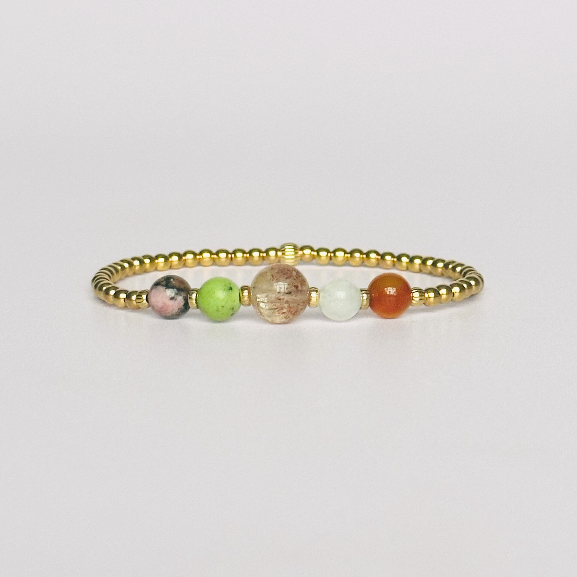 This gold vermeil Cancer bracelet is made with a selection of five healing crystals all believed to resonate with the Cancer zodiac sign. The central bead is 8mm, the other four are 6mm. On an elasticated band of 3mm gold vermeil beads with corrugated accent beads. Featuring chrysoprase, rhodonite, sunstone, moonstone and carnelian.