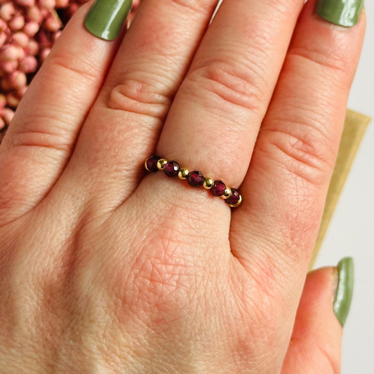 Gold vermeil garnet ring featuring five 3mm faceted round garnet beads on a elasticated ring band of 2.5mm gold vermeil beads. January birthstone ring.