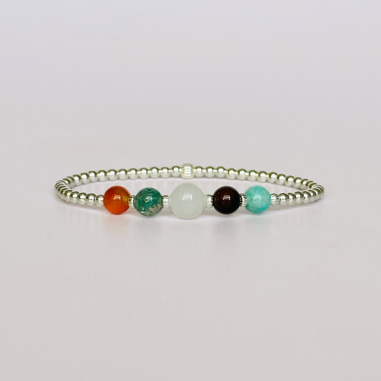 This sterling silver Virgo bracelet is made with a selection of five healing crystals all believed to resonate with the Virgo zodiac sign. The central bead is 8mm, the other four are 6mm. On an elasticated band of 3mm sterling silver beads with corrugated accent beads. Featuring amazonite, carnelian, moonstone, moss agate and sardonyx.