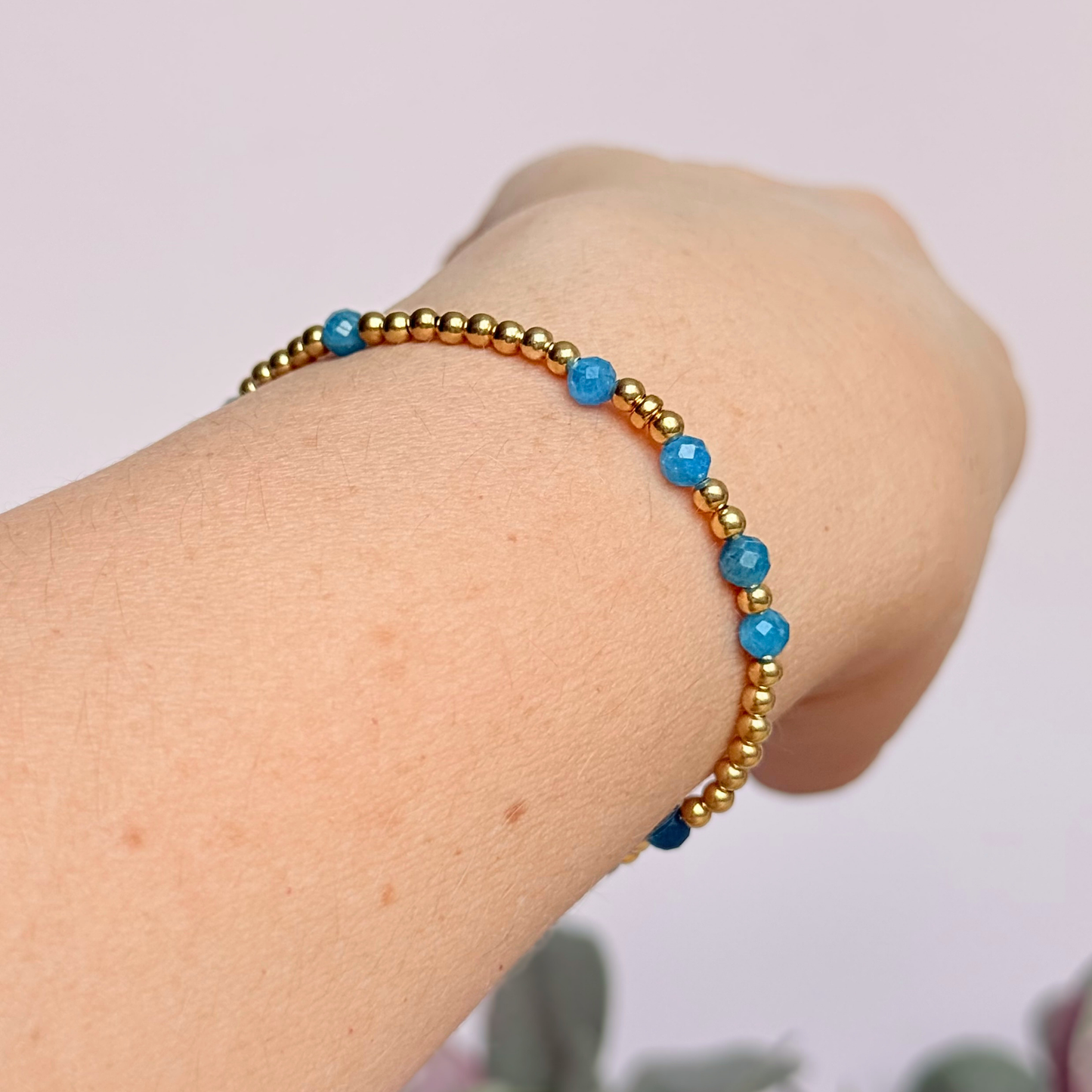 Apatite morse code bracelet that spells out the words ‘Ask, believe, receive’ in a combination of 4mm round smooth and faceted crystal beads with your choice of sterling silver or gold vermeil accent beads. Pictured in gold, being worn at an angle