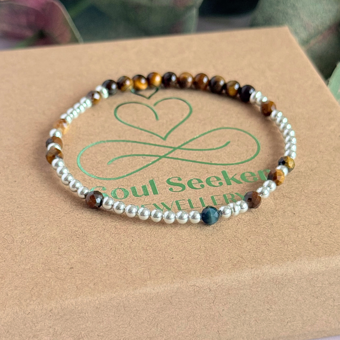 Tigers eye morse code bracelet that spells out the words ‘Ask, believe, receive’ in a combination of 4mm round smooth and faceted crystal beads with your choice of sterling silver or gold vermeil accent beads. Pictured in silver, on top of the box