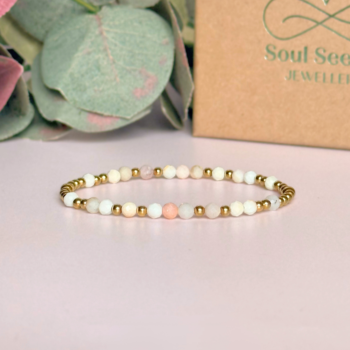 Dainty, minimalist gold vermeil and pink opal October birthstone stacking bracelet. Made with 4mm faceted pink opal beads and 3mm gold vermeil round beads. Elasticated for comfort. Pictured in front of the gift box