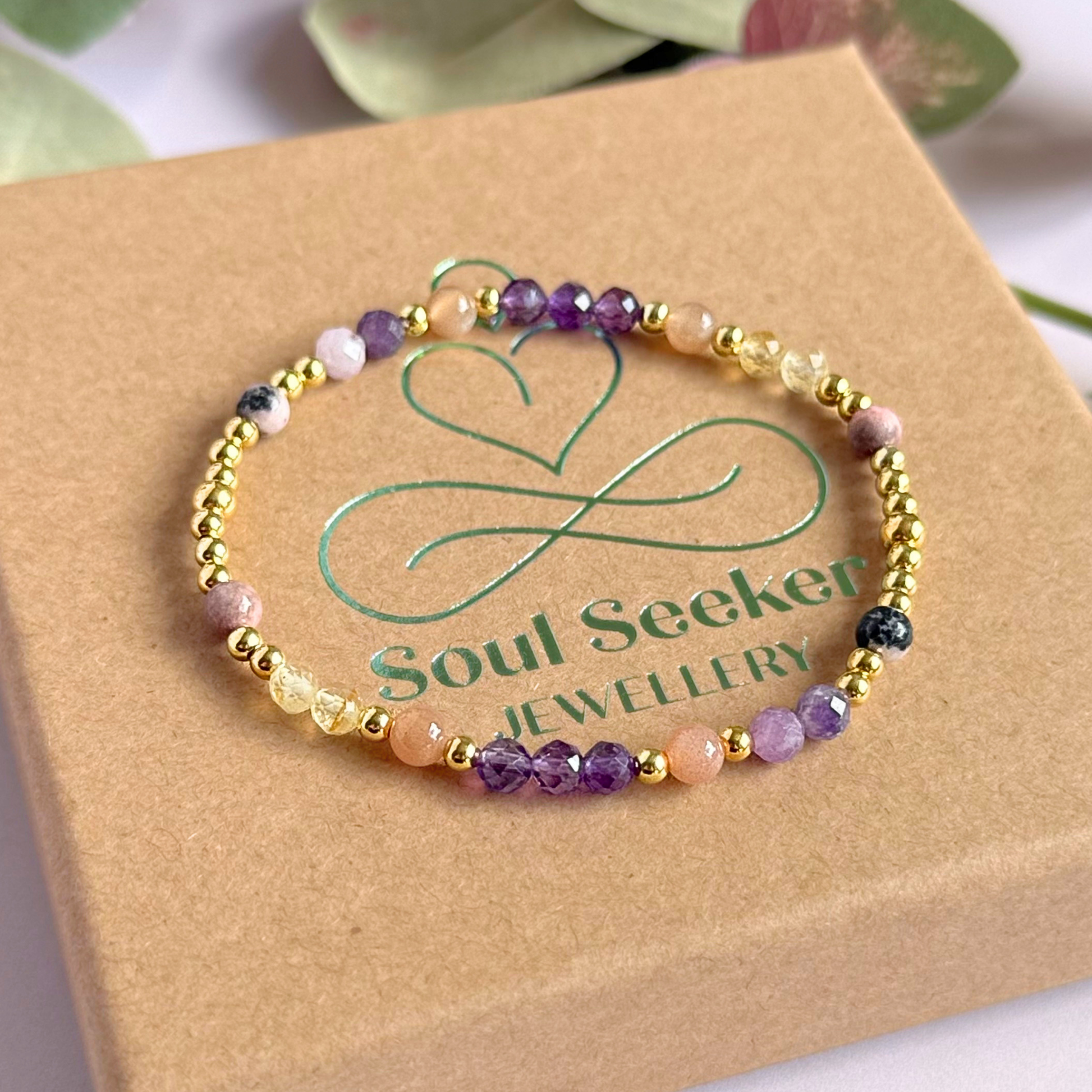 Dainty gold vermeil crystal bracelet featuring five crystals, in 4mm faceted and smooth round style, each believed to help with menopause symptoms. Featuring amethyst, citrine, lepidolite, peach moonstone and pink zebra jasper. Pictured on top of gift box.