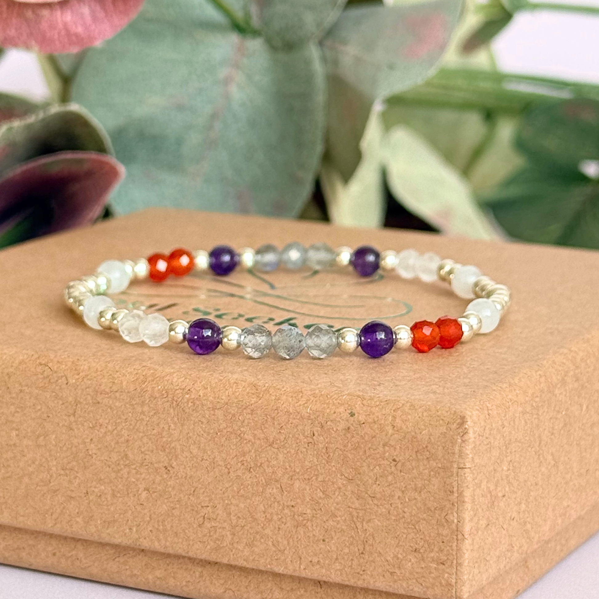 Dainty sterling silver crystal bracelet featuring five crystals, in 4mm faceted and smooth round style, each believed to help with hormonal balance. Featuring amethyst, moonstone, carnelian, labradorite and rose quartz. Pictured on top of the gift box.