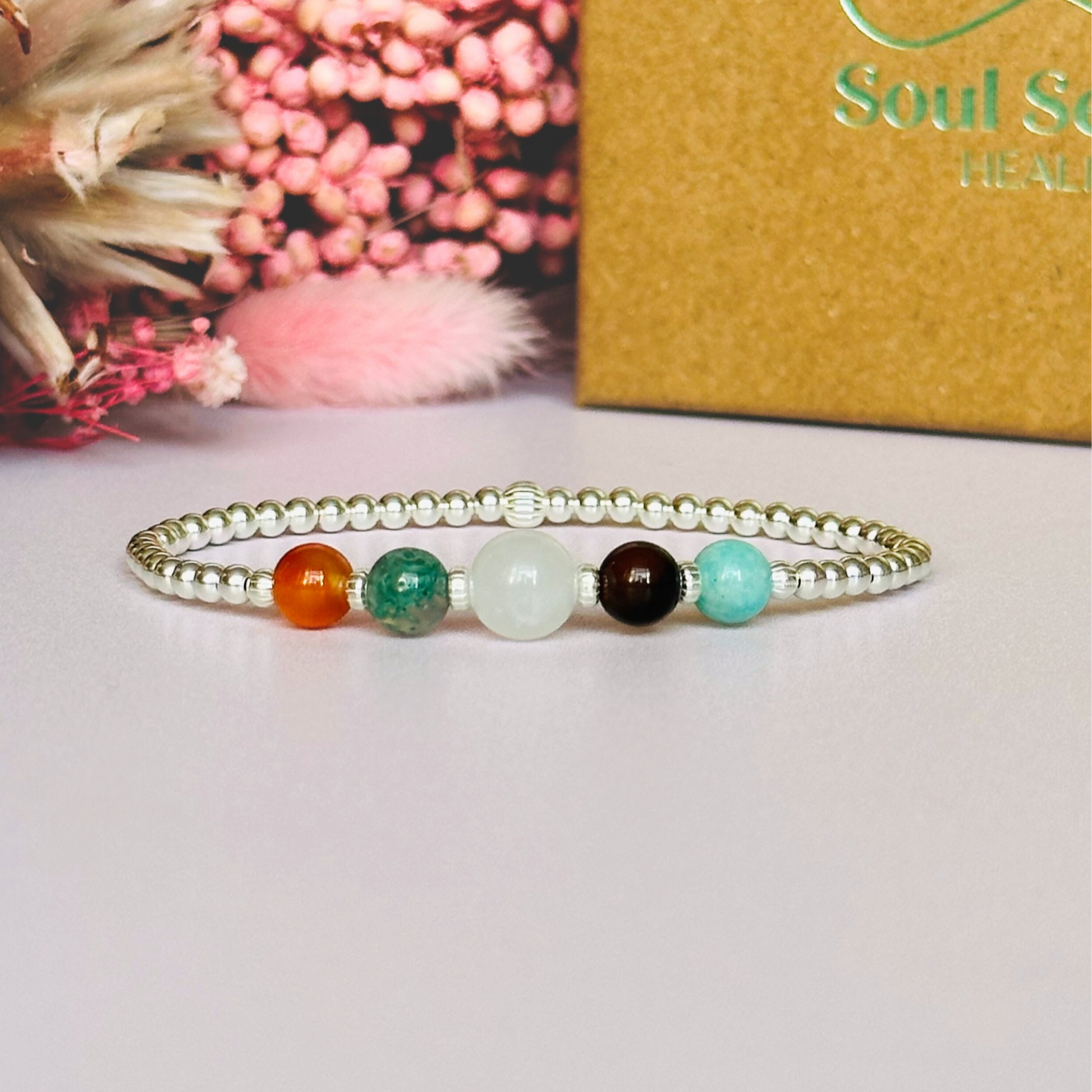 This sterling silver Virgo bracelet is made with a selection of five healing crystals all believed to resonate with the Virgo zodiac sign. The central bead is 8mm, the other four are 6mm. On an elasticated band of 3mm sterling silver beads with corrugated accent beads. Featuring amazonite, carnelian, moonstone, moss agate and sardonyx.
