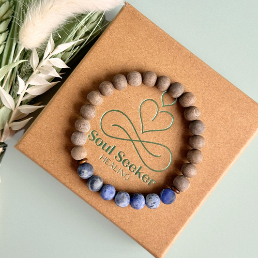 Mens crystal healing bracelet featuring 8mm frosted sodalite beads, grey wood beads and sandalwood spacer beads.