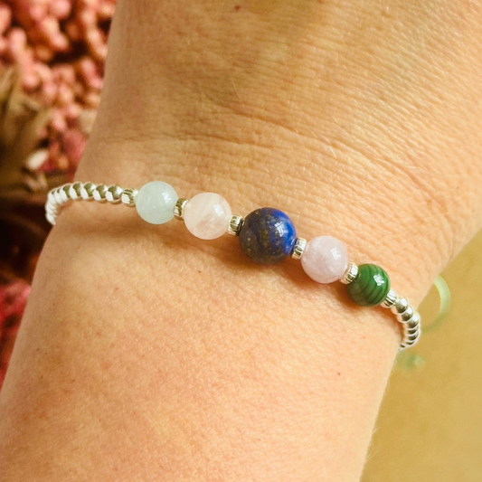 This sterling silver Taurus bracelet is made with a selection of five healing crystals all believed to resonate with the Taurus zodiac sign. The central bead is 8mm, the other four are 6mm. On an elasticated band of 3mm sterling silver beads with corrugated accent beads. Featuring malachite, lapis lazuli, rose quartz, kunzite and aquamarine.
