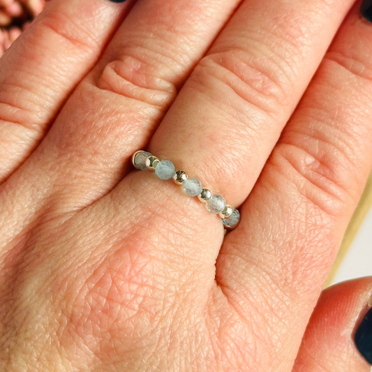 Sterling silver aquamarine ring featuring five 3mm faceted round aquamarine beads on a elasticated ring band of 2.5mm gold vermeil beads. March birthstone ring.