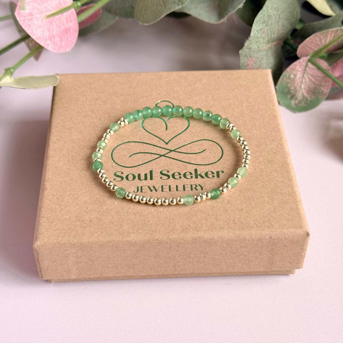 Green aventurine morse code bracelet that spells out the words ‘Ask, believe, receive’ in a combination of 4mm round smooth and faceted crystal beads with your choice of sterling silver or gold vermeil accent beads. Pictured on the box, in silver