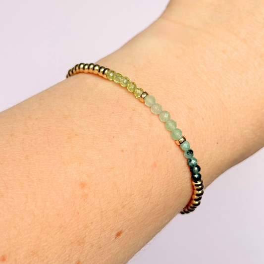 Dainty minimalist yellow gold filled crystal bracelet featuring 3mm faceted emerald, peridot and green aventurine beads in a colour block Ombre style. Fastens with a gold filled lobster clasp with an extender chain.