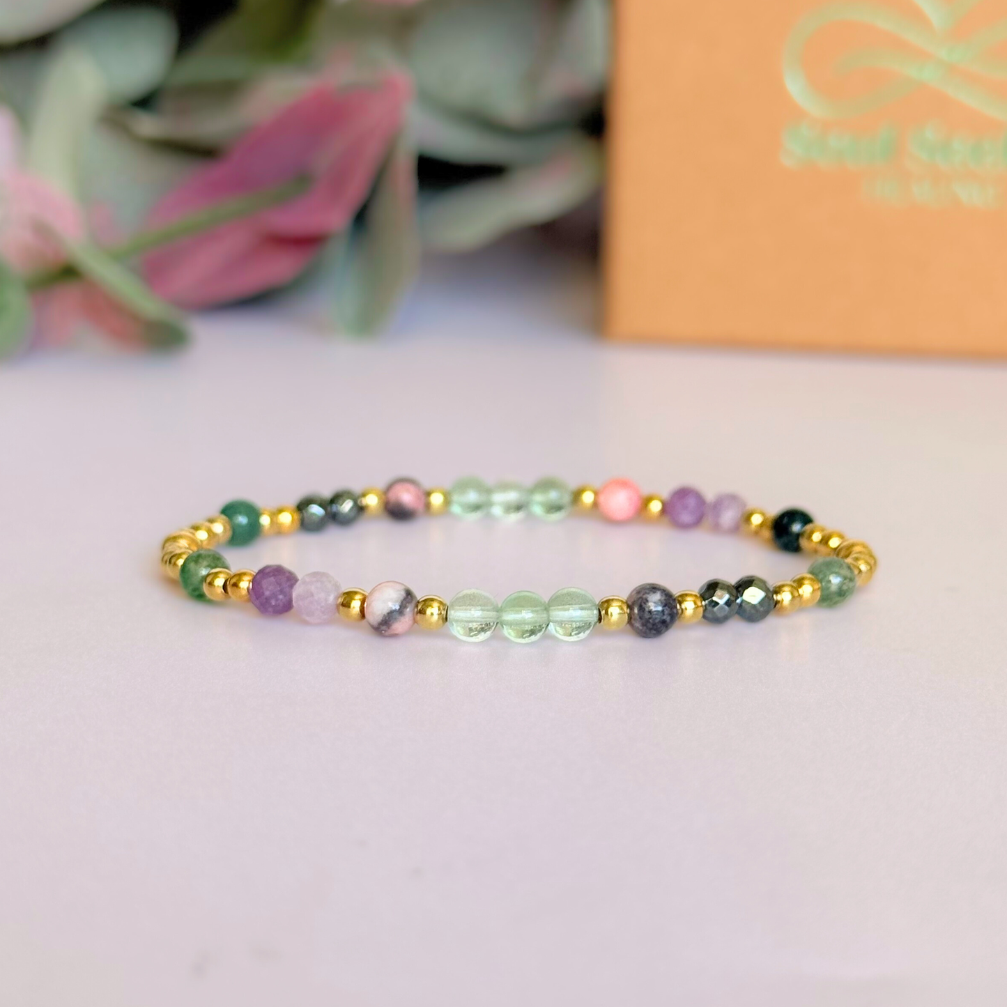 Dainty crystal bracelet featuring five crystals all believed to help with focus, clarity and overwhelm. Featuring fluorite, hematite, lepidolite, moss agate and pink zebra jasper. Featuring 3mm gold vermeil round beads and 4mm faceted round and smooth round crystal beads. Pictured in front of the gift box.￼