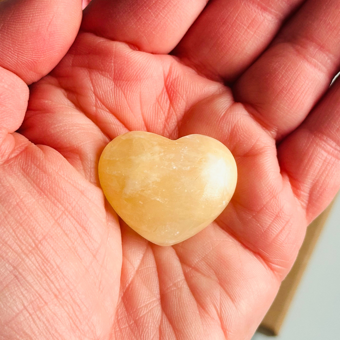 A beautiful ethically mined yellow calcite heart, presented on an eco-friendly textured card with the words 'A stone of joy and confidence.' This heart shaped crystal measures approximately 25mm x 25mm.
