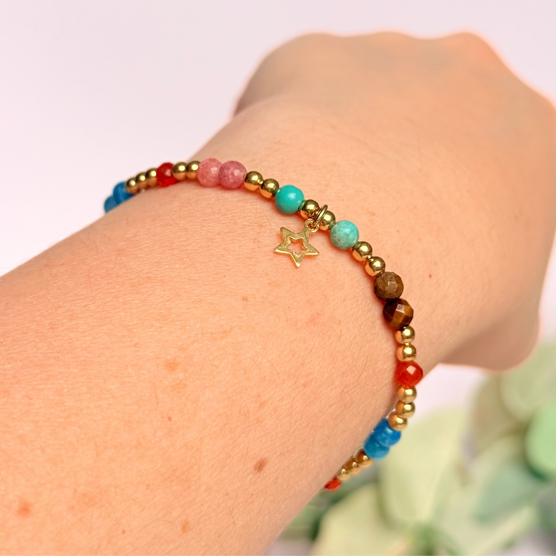 'Hot girl summer' gold vermeil dainty beaded bracelet with tigers eye, turquoise, apatite, carnelian and rhodochrosite. With a beautiful open star charm.Made with round 3mm gold vermeil beads and 4mm smooth and faceted round crystal gemstone beads. Pictured being worn, shown on an angle.