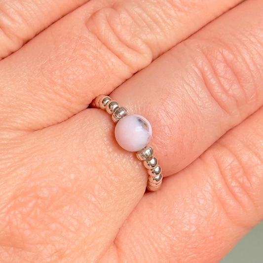 Sterling silver pink opal October birthstone ring featuring a 6mm smooth, round pink opal bead on a band of 2.5mm sterling silver ball beads. Elasticated for comfort.