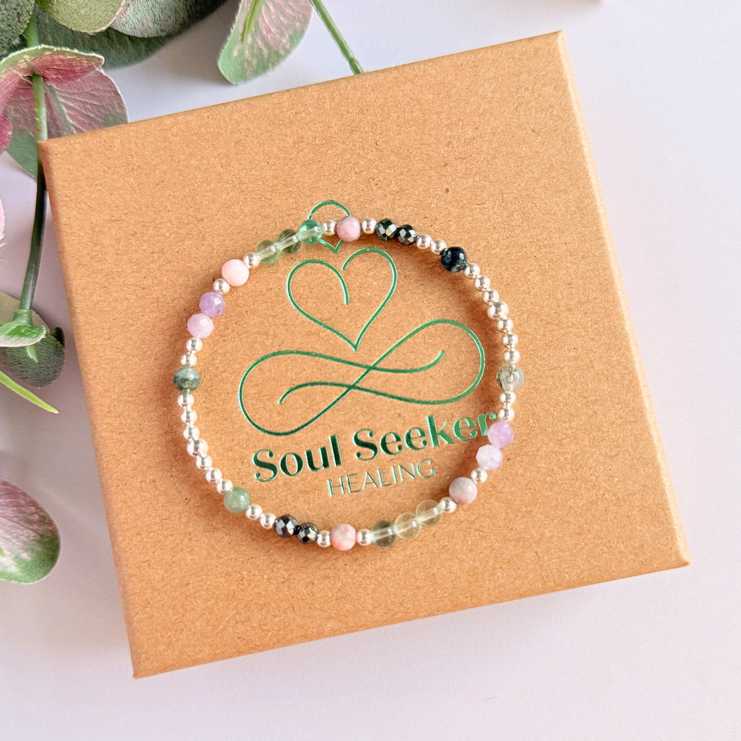 Dainty crystal bracelet featuring five crystals all believed to help with focus, clarity and overwhelm. Featuring fluorite, hematite, lepidolite, moss agate and pink zebra jasper. Featuring 3mm sterling silver round beads and 4mm faceted round and smooth round crystal beads. Pictured on top of the gift box.