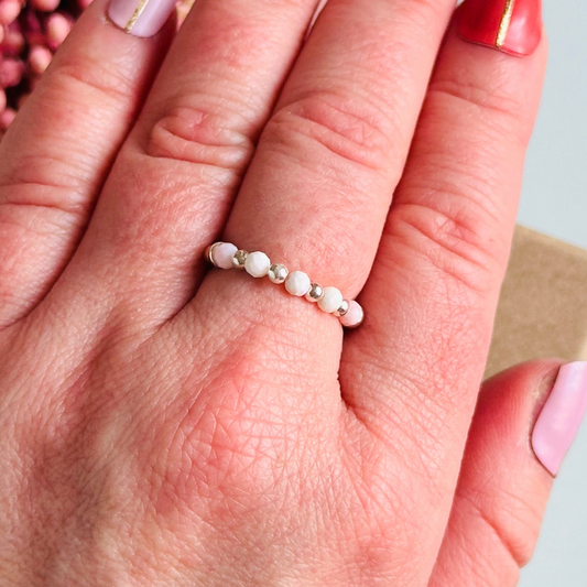 Birthstone ring featuring 5 3mm. Faceted Peruvian pink opal beads on an elasticated band of 3mm sterling silver round beads, pink opal is an October birth stone so this makes a perfect October birthday gift.