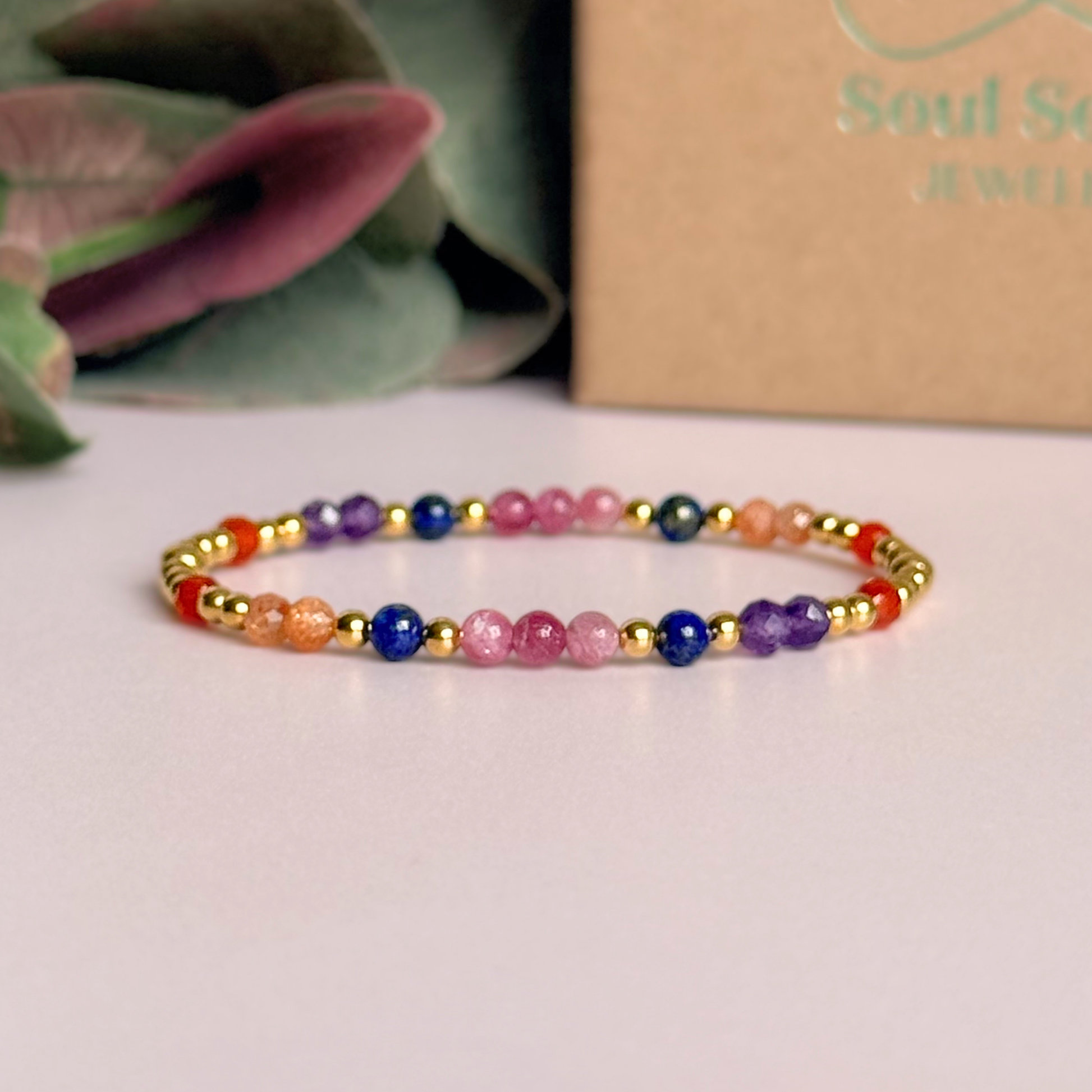 ‘Arabian Sunset' gold vermeil dainty beaded bracelet with pink tourmaline, sunstone, carnelian, lapis lazuli and amethyst. Made with round 3mm gold vermeil beads and 4mm smooth and faceted round crystal gemstone beads. Pictured in front of the gift box.