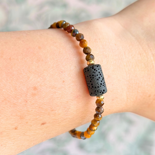 Essential oil diffuser bracelet featuring black lava rock tube bead on the band of 4mm faceted tigers eye beads. Finished with your choice of sterling silver or gold vermeil accent beads.