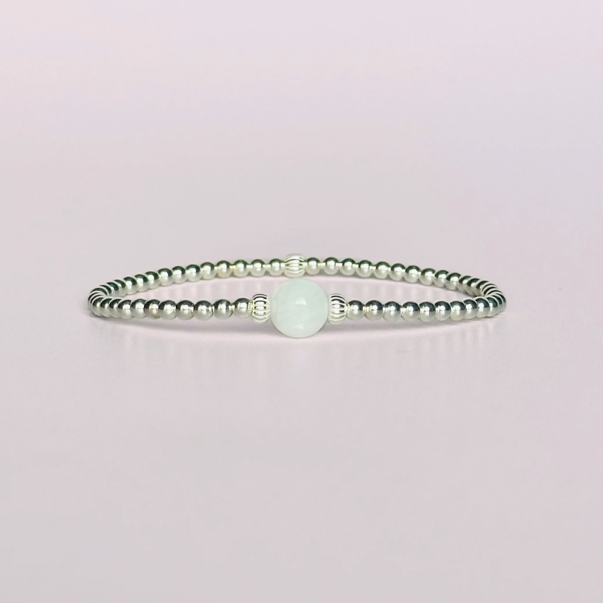 Sterling silver moonstone bracelet features an ethically mined 8mm moonstone bead, flanked by corrugated rondelle beads on a band of 3mm sterling silver beads. A bracelet to promote feminine energy and intuition.