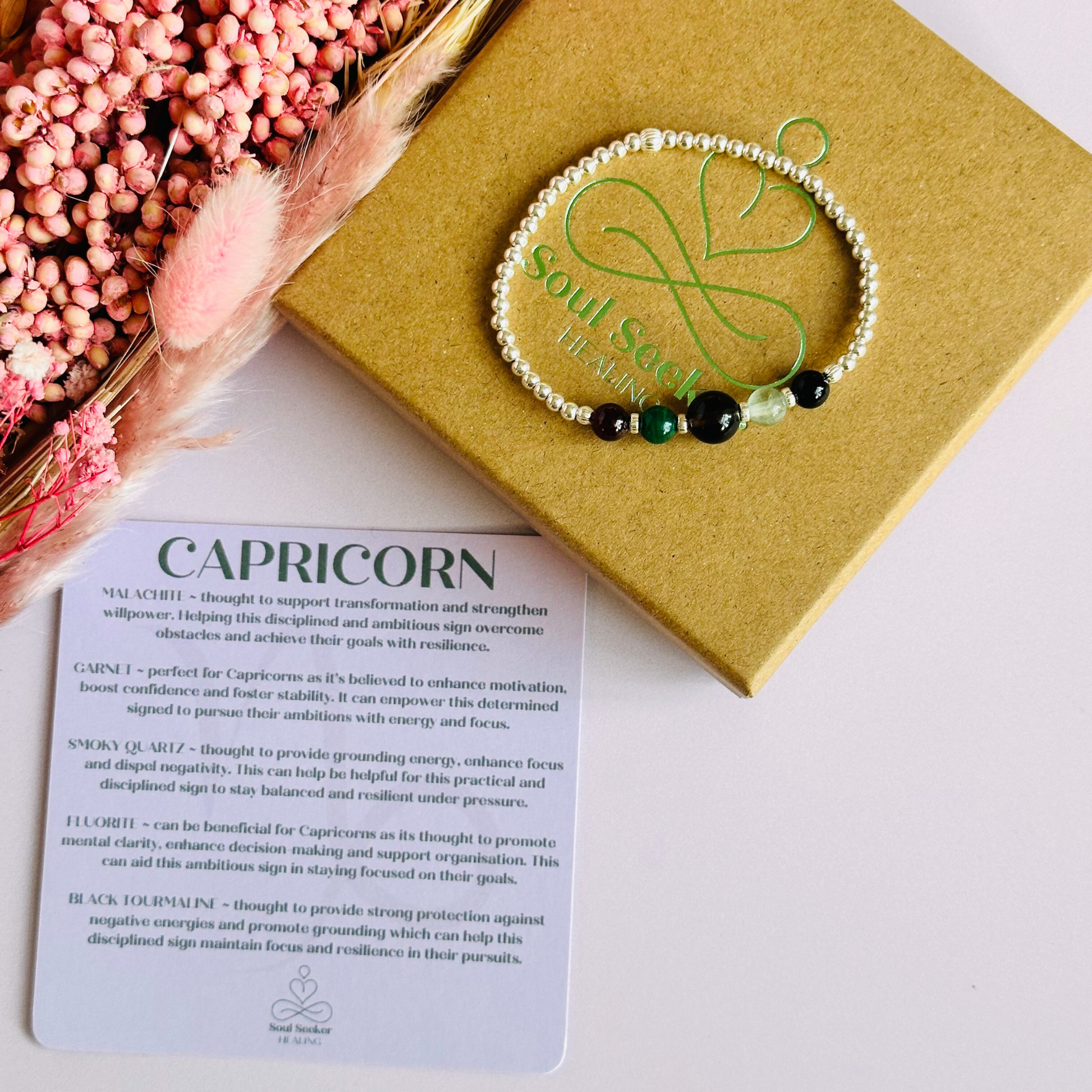This sterling silver Capricorn bracelet is made with a selection of five healing crystals all believed to resonate with the Capricorn zodiac sign. The central bead is 8mm, the other four are 6mm. On an elasticated band of 3mm sterling silver beads with corrugated accent beads. Featuring garnet, malachite, fluorite, smoky quartz and black tourmaline.